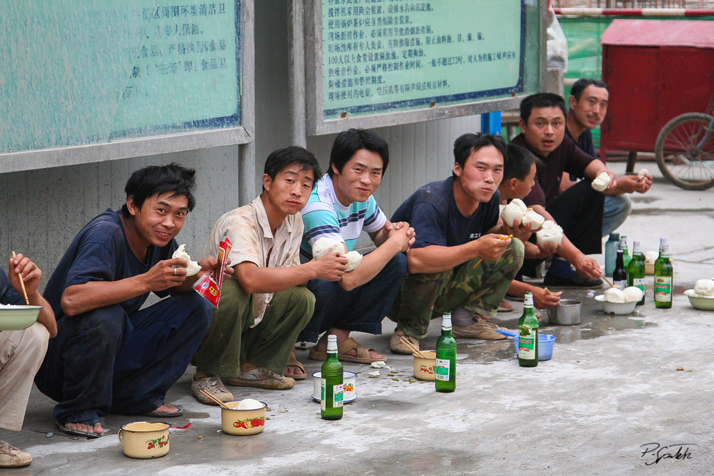 Workers having dinner near they working place. Beijing 20.07.07