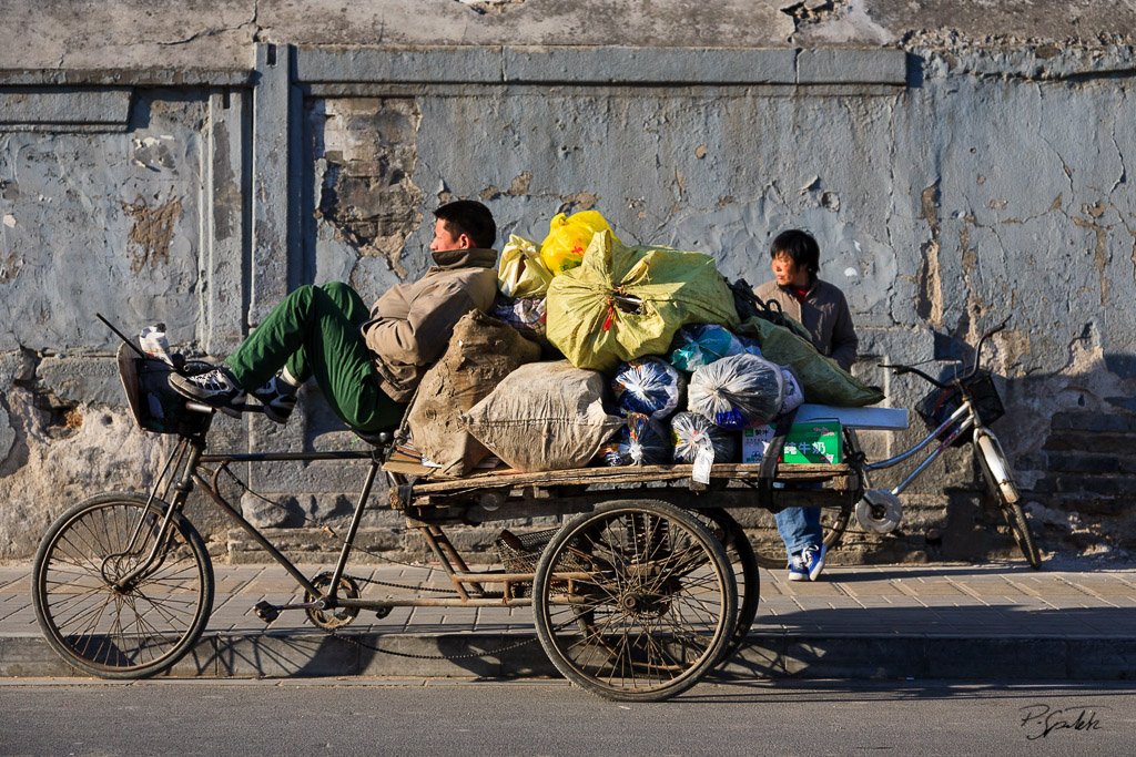 Paper and bottle gatherers relaxing on the street. Beijing 06.03.08